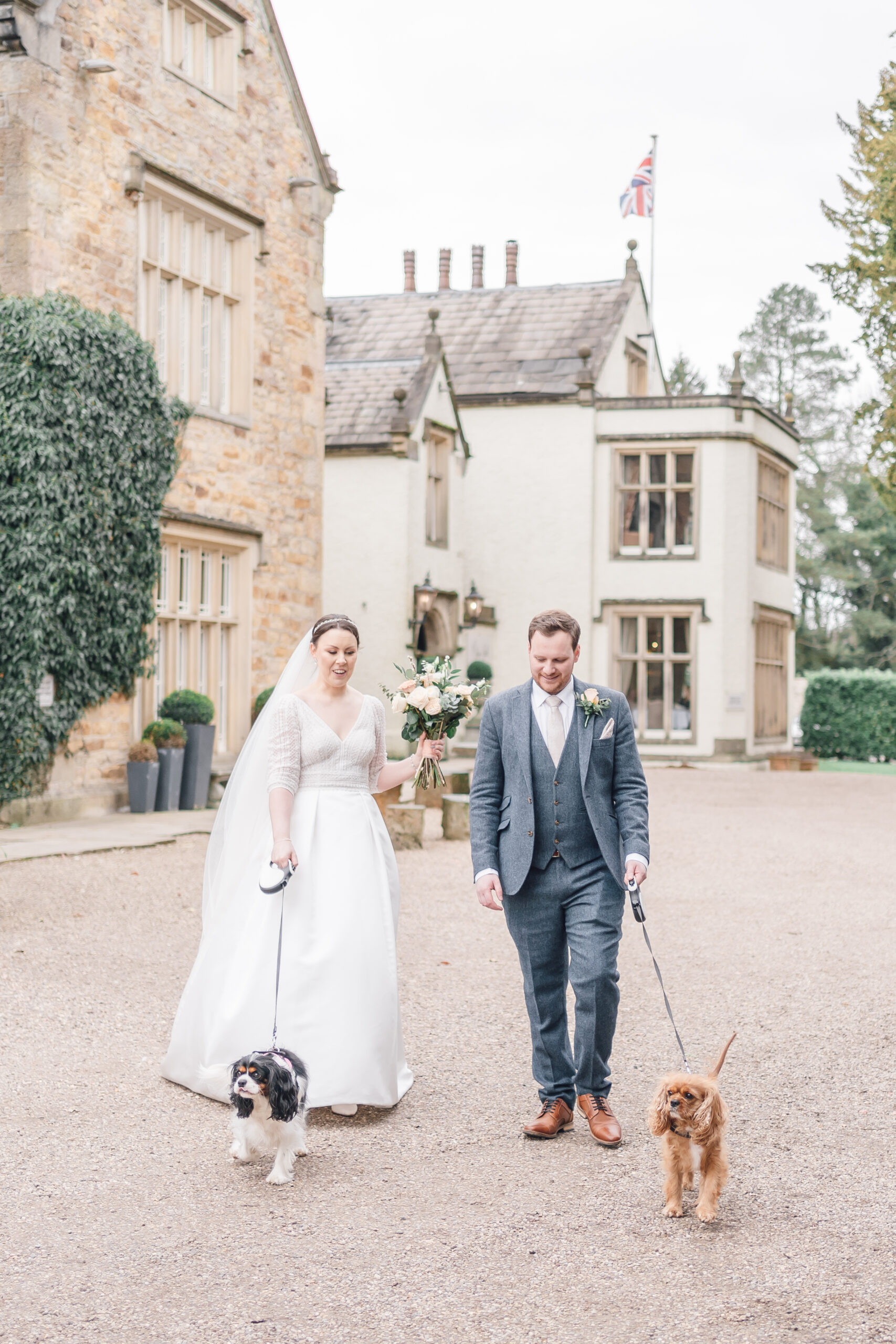 bride and groom walking dogs at Mitton Hall wedding